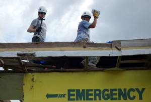 Helping to cover the roof of the emergency room to keep patients dry during constant rainstorms.